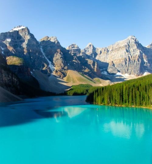 Picturesque scenery of calm turquoise water of river flowing among rocky mountains in sunny day